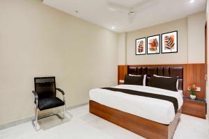 Un dormitorio con una cama grande y una silla. en Collection O Taj Nagri Phase 2, en Agra