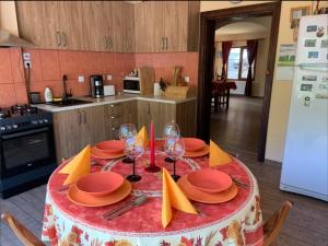 a kitchen with a table with plates and wine glasses at Casa Bianca in Băile Herculane