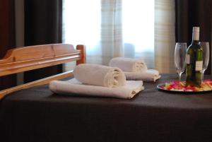a table with towels and a bottle of wine and glasses at Studios Filippina in Skala Potamias