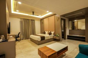 a hotel room with a bed and a living room at Hotel The Golden Tree in Prayagraj +11 photos