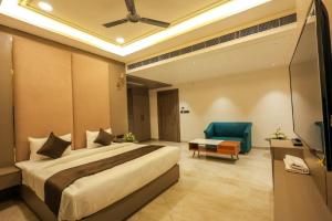 a bedroom with a large bed and a blue chair at Hotel The Golden Tree in Prayagraj