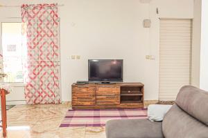 a living room with a flat screen tv on a dresser at Villa Eruptif - Proche Volcan - 15pers - By Sister Home in Le Tampon