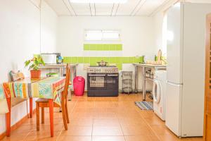 a kitchen with a stove and a table and a refrigerator at Villa Eruptif - Proche Volcan - 15pers - By Sister Home in Le Tampon