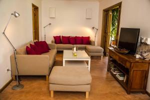 a living room with a couch and red pillows at Villa Ixora - Ocean Front in Las Galeras
