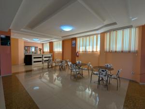 a room with tables and chairs and a kitchen at Panorama hotel kobuleti in Kobuleti