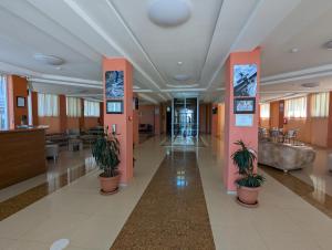 a hospital lobby with pink columns and potted plants at Panorama hotel kobuleti in Kobuleti