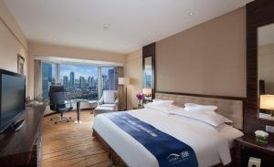 上海上海静安昆仑大酒店的一间酒店房间，配有一张大床和一张书桌