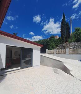 un edificio con una gran ventana a un patio en Smokvica, en Senj 11 fotos más