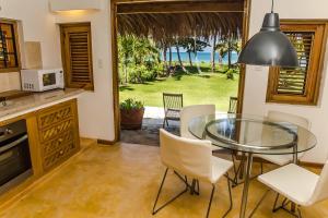 a kitchen and dining room with a glass table and chairs at Jasmine La Playita - Ocean Front in Las Galeras