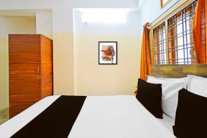 a bedroom with a white bed and a window at Super Collection O Suncity in Hyderabad