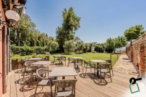 a deck with tables and chairs and a lawn at Hotiday Venezia Cape in Venice