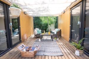 a screened in porch with a couch and a table at UMILI Pod Cyprysami - surf & family resort in Jastarnia