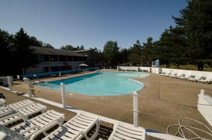 a swimming pool with white chairs and a bunch at Brennan Beach Lakeview Park Model 1 in Pulaski