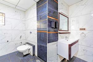 a bathroom with a toilet and a sink at Super Hotel O Indiranagar in Bengaluru