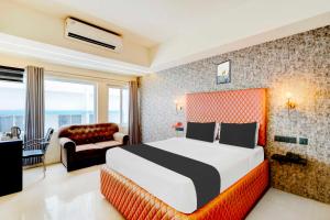 una camera d'albergo con un letto e un divano di Collection O Mysore Central a Mysore