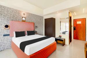 una camera da letto con un letto grande in una stanza di Collection O Mysore Central a Mysore Altre 23 foto