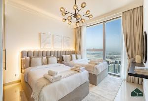 Dos camas en una habitación con una gran ventana. en High Floor 2BR with Full Burj View by BMS, en Dubái 37 fotos más