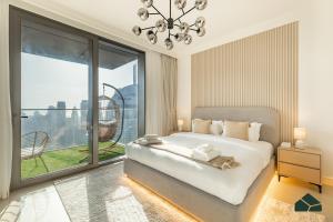 Un dormitorio con una cama grande y una ventana grande. en High Floor 2BR with Full Burj View by BMS, en Dubái