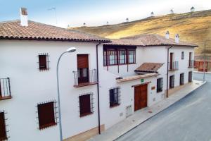 a row of white buildings with a street light at Casa Rural Alcancia in Consuegra