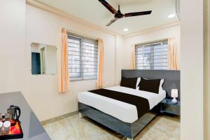 a bedroom with a bed and two windows at Townhouse Oak Visakhapatnam Lumbini Park in Visakhapatnam