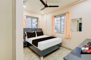 a bedroom with a bed in a room with windows at Townhouse MVP Circle Visakhapatnam in Visakhapatnam +20 photos