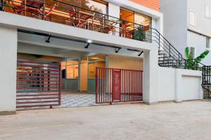 a house with a red gate and a staircase at Townhouse Oak Visakhapatnam Lumbini Park in Visakhapatnam