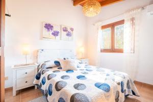 a bedroom with a bed with a blue and white comforter at Villa Marilen in Santa Margalida +20 photos