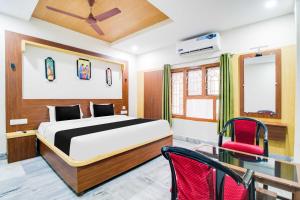 a bedroom with a bed and a red chair at Collection O Ramakrishna Beach in Visakhapatnam