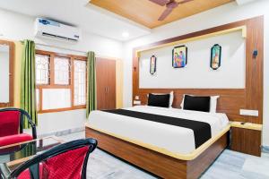 a bedroom with a bed and a red chair at Collection O Ramakrishna Beach in Visakhapatnam