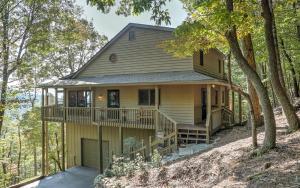 a house with a wrap around porch in the woods at Wine Down Cottage - Mountain Views Sip Wine Fireside Watch Netflix Play Golf in Jasper