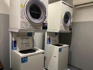 three washers and dryers on display in a room at APA Hotel Owari Ichinomiya Eki-mae in Ichinomiya