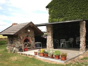 a stone house with a patio with plants in front of it at Ferienwohnungen auf dem Lande in Kittendorf