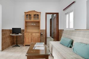 a living room with a couch and a tv at Juani en Conil in Conil de la Frontera