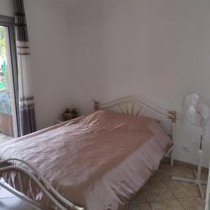 a bed in a bedroom with a white wall at Maison Villa d'exception meublée piscine privée & cheminée a 2min plage et commerces in Marseillan +26 photos