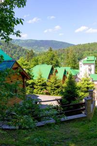 a group of buildings with green roofs and trees at Sofia Forest Club in Yaremche