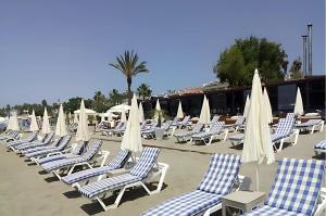 Un montón de sillas y sombrillas en una playa en Livane Sun Otel, en Alanya