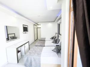 Dos camas en una habitación con paredes blancas. en Livane Sun Otel, en Alanya