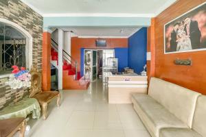 a living room with orange and blue walls and a couch at Alza 2 Cianjur Mitra RedDoorz in Tjiandjur