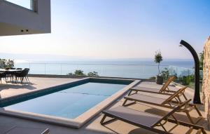 a house with a swimming pool and a patio with chairs at Stunning Home In Medveja in Medveja