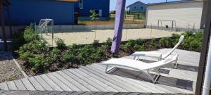a couple of white chairs sitting on a wooden deck at Villa Wildrose mit Sauna und Beachfußballplatz in Rheinsberg