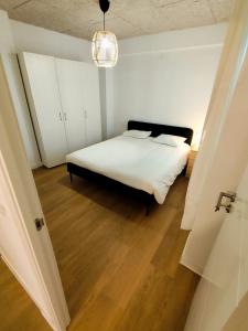 a bedroom with a white bed and a chandelier at Dúplex soleado cerca del mar in Santoña