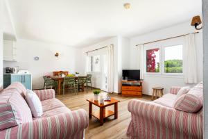 Una sala de estar con dos sofás y una mesa. en Villa Juana - Torre Solí, en Son Bou