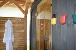 a bathroom with a shower with a white robe on the wall at Fleesenseetreppe rechts in Göhren-Lebbin
