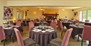 Hostellerie du Causse في غرامات: غرفة طعام مع طاولات وكراسي وحارق طاولات