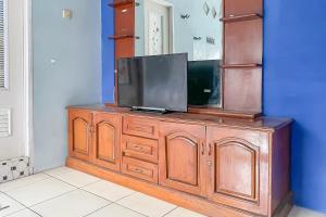 a television on top of a wooden dresser at Alza 2 Cianjur Mitra RedDoorz in Tjiandjur +16 photos
