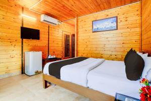 a bedroom with a bed in a wooden room at Collection O Morjim Beach in Goa