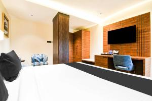 a hotel room with a bed and a flat screen tv at Collection O Pardih Brahmananda Narayana Hospital in Jamshedpur