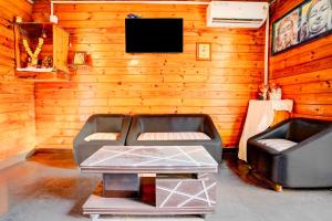 a living room with two leather chairs and a table at Collection O Morjim Beach in Goa