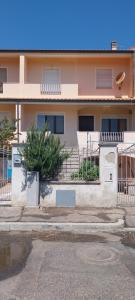 un edificio con escaleras y un árbol delante de él en Casa Kimbe, en Oristano