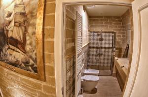 グラヴィーナ・イン・プーリアにあるDomus Decclesiisのレンガの壁にトイレ2つが付いたバスルーム